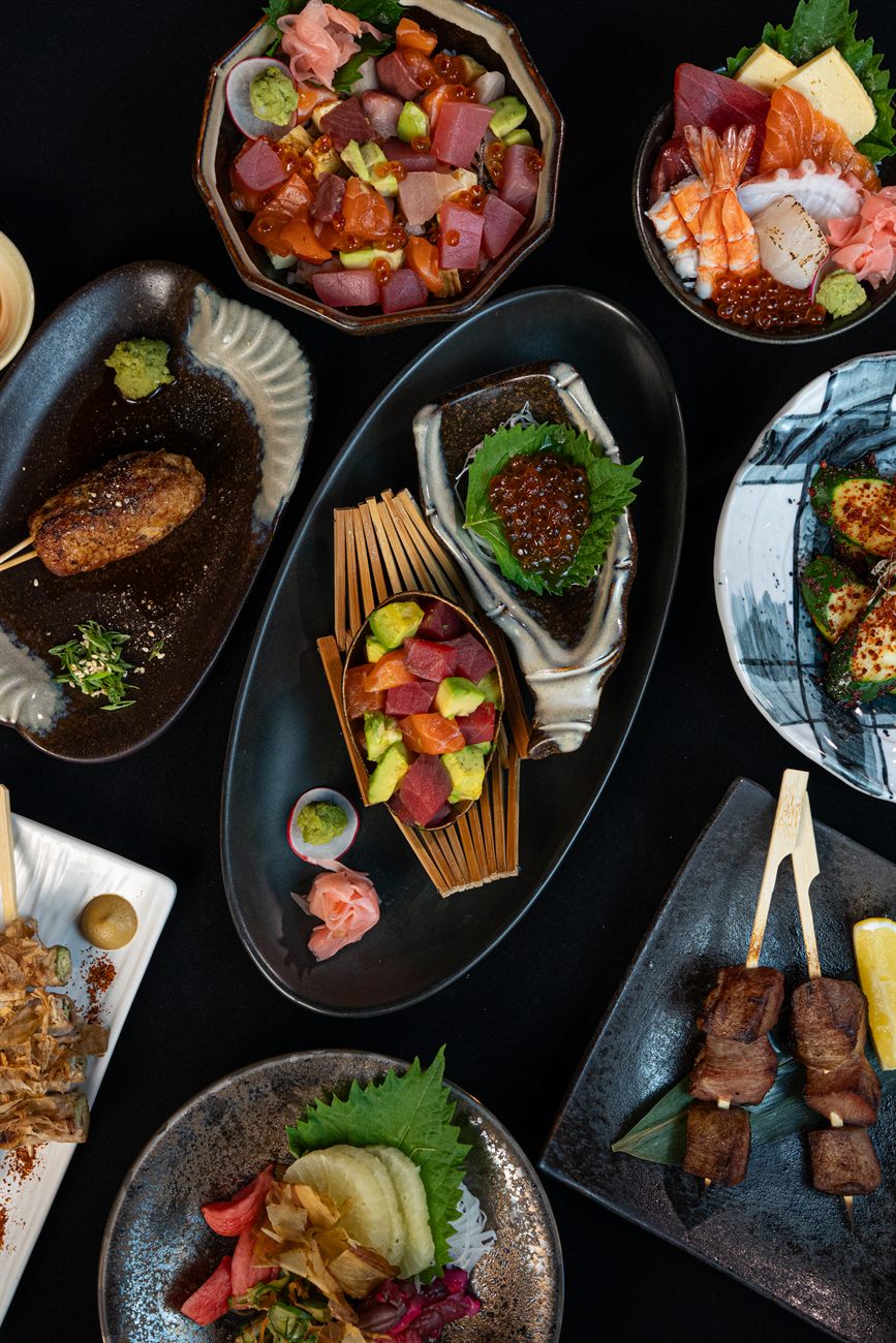 A spread of Kura Samui izakaya small plates: skewers, sashimi and rice bowls